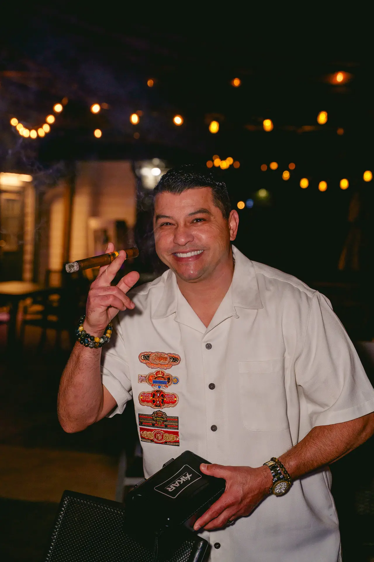 smiling man with a cigar at Ember & Vine