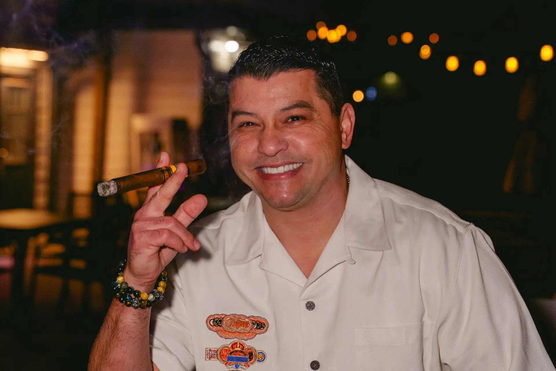 smiling man with a cigar at Ember & Vine
